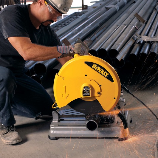 Chop Saw with QUIK-CHANGE™ Keyless Blade Change System being used by a person to cut metal pipes
